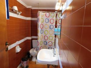 a bathroom with a shower curtain and a sink at Perdika Mare Guesthouse in Perdika