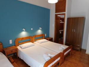 a bedroom with two beds and a blue wall at Perdika Mare Guesthouse in Perdika