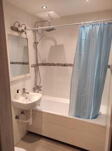 une salle de bain avec un lavabo, une baignoire et une douche dans l'établissement Studija Centre, à Klaipėda