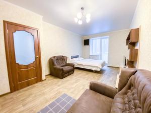 a living room with a couch and a bed and a door at ApartPoltava Простора однокімнатна квартира в НОВОМУ будинку в самому серці Полтави, Банківський ЧЕК in Poltava