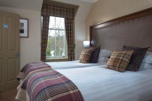 a bedroom with a large bed with pillows at Cairngorm Hotel in Aviemore
