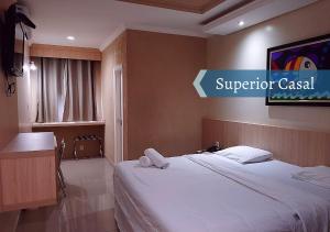 una habitación de hotel con una cama y un cartel que dice casino superior en Biss Inn Hotel, en Goiânia