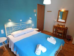 a blue bedroom with a bed with towels on it at Perdika Mare Guesthouse in Perdika