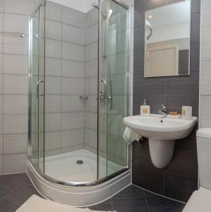 a bathroom with a glass shower and a sink at Lovely 3BD flat with PARKING and SEA VIEW by Flаt Manаger in Chernomorets