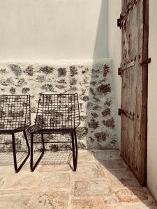 twee stoelen in een kamer met een muur bij yours trulli in Martina Franca