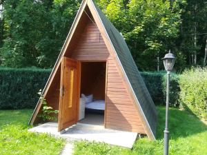 una pequeña casa de perros con una puerta en un patio en Ferienhaus am Wald, en Loissin