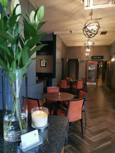 a vase with a candle on a table in a restaurant at Fir Trees Hotel in Strabane