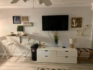 a living room with a tv on a wall at Daytona Beach Inn Resort in Daytona Beach
