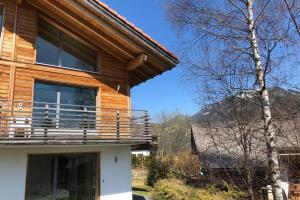 uma casa de madeira com uma varanda ao lado em Région de GSTAAD, charmant chalet duplex de 80m2 em Zweisimmen