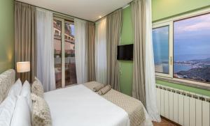 a bedroom with a bed and a large window at Villa Le Terrazze Charming Rooms in Taormina