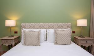 a bed with a white comforter and pillows at Villa Le Terrazze Charming Rooms in Taormina