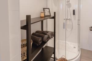 ein Badezimmer mit einem Regal mit Handtüchern und einer Dusche in der Unterkunft Madrid Suites in Maastricht