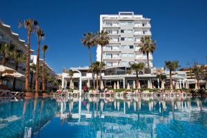 a hotel with a swimming pool in front of a building at Hotel Riu Nautilus - Adults Only in Torremolinos