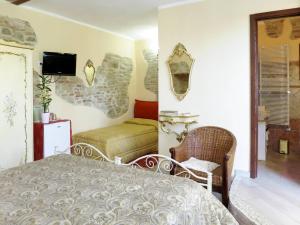 a bedroom with a bed and a chair and a tv at River Melody B&B in Bettona