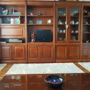 a large wooden entertainment center with a tv and a bowl at Garsoniera Mihaela in Petroşani