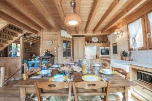 圣沙夫雷Chalet Hibou, large chalet with mountain views and close to slopes的配有木桌椅的厨房和餐厅
