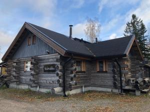 a log cabin with a black roof at Kelotulkku Lodge in Muurame