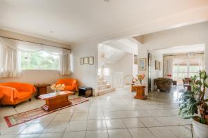 a living room with orange furniture and a staircase at OYO Hotel Vila Rica, Ribeirão Preto in Ribeirão Preto