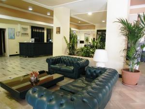 a lobby with a leather couch and a table at Hotel Park Siracusa Sicily in Siracusa