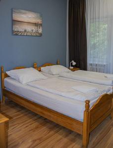 a bedroom with two beds with white sheets and a window at Olimpik Park in Słubice