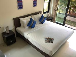 a bedroom with a large bed with blue and white pillows at Baan Piengfah Holiday Home Ao Nang in Ao Nang Beach