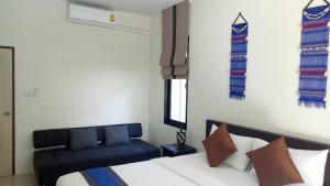 1 dormitorio con 1 cama y 1 sofá azul en Baan Piengfah Holiday Home Ao Nang, en Ao Nang Beach