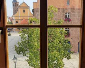 a window with a view of a street and a church at Ferienwohnung Abel in Heideck