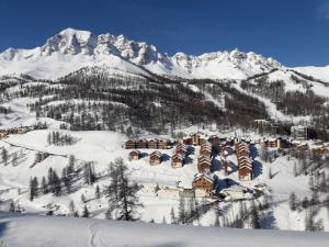 a resort in the snow with a mountain in the background at Boost Your Immo Vars Chalet Des Rennes 210 in Vars