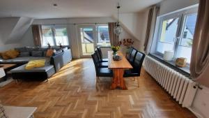 ein Wohnzimmer mit einem Tisch, Stühlen und einem Sofa in der Unterkunft Ferienwohnung Rolf in Crottendorf