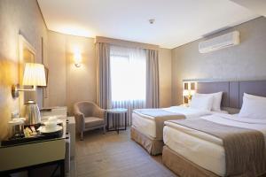 um quarto de hotel com duas camas e uma janela em Polatdemir Hotel em Istambul