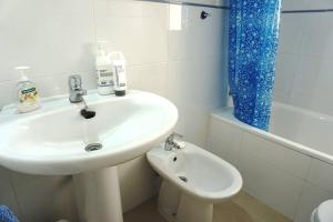 biała łazienka z umywalką i toaletą w obiekcie Fantastic Location - Penthouse Duplex in Cabo Roig in walking distance to the beach w mieście Cabo Roig +37 zdjęć