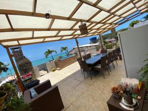 a patio with a table and chairs and the ocean at Casa Baroni in Pipa