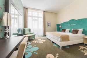 a bedroom with a bed and a desk and a chair at La Prima Fashion Hotel Budapest in Budapest