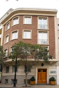 un edificio in mattoni rossi con una porta marrone di Lastarria Hotel & Aparts a Santiago