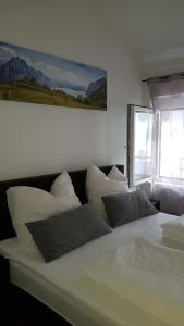 基希比希爾的住宿－Appartement Spitzenstätter，一张白色的床,配有白色枕头,墙上挂着一张照片