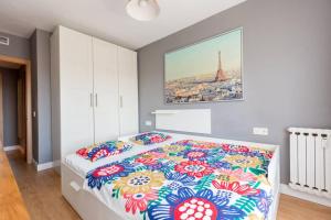 a bedroom with a bed with a colorful comforter at SANTANDER - Apartamento ejectutivo con garaje in Zaragoza