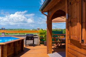 an outdoor patio with a pool and a grill at Noubana Au Coeur Des Cannes Avec Piscine Chauffée in Lamentin