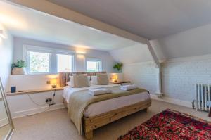 a bedroom with a bed and a desk and a window at Luxury Victorian school with views of Harbour in Fowey +28 photos