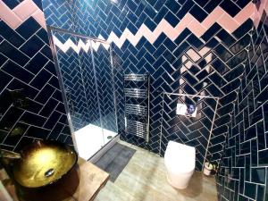 a bathroom with a toilet and blue and pink tiles at Angel Townhouse in London
