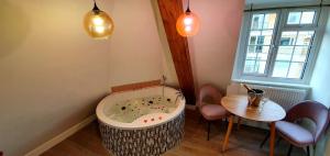 a bath tub in a room with a table and chairs at Angel Townhouse in London