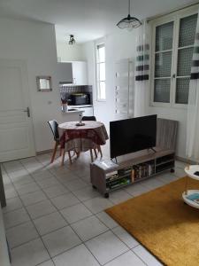 un salon avec une table et une télévision dans l'établissement appartement cosy au calme et en centre ville, à Aix-les-Bains