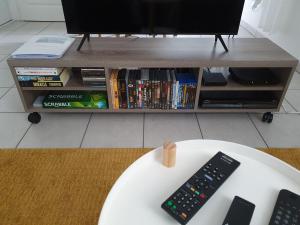 - une télécommande assise sur une table devant une télévision dans l'établissement appartement cosy au calme et en centre ville, à Aix-les-Bains