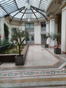エクスレバンにあるappartement cosy au calme et en centre villeの鉢植えの木とガラスの天井があるコンサバトリー