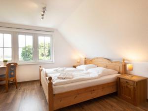 um quarto com uma cama, uma secretária e janelas em Ferienhaus Wolkenlos em Neu Pastitz