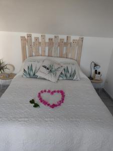 un corazón hecho de flores en una cama en La Plaine-itude & Spa en Saint-Paul