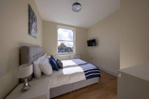 1 dormitorio con cama con almohadas y ventana en Apartment 5, Isabella House, Aparthotel, By RentMyHouse, en Hereford