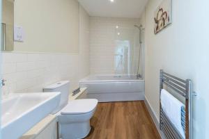 a bathroom with a toilet and a tub and a sink at Apartment 5, Isabella House, Aparthotel, By RentMyHouse in Hereford