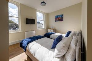 a bedroom with two beds with blue pillows at Apartment 5, Isabella House, Aparthotel, By RentMyHouse in Hereford