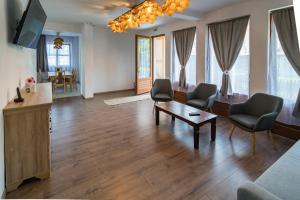ein Wohnzimmer mit Sofa, Stühlen und einem Tisch in der Unterkunft Pensiunea Agroturisticā Lukács Panzió in Ujfalù