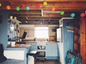 基督城Stargazing Beach Hut on Mudeford Sandbank with wake up sea views的配有炉灶和冰箱的厨房